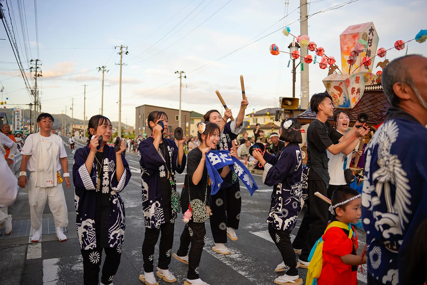 山田祭りの沿道で鉦を打ち鳴らす山田大神楽の法被姿の女性たち