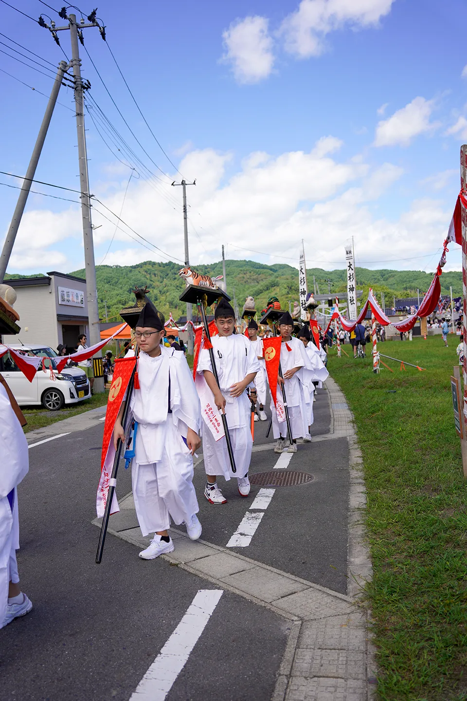 山田祭りで干支の御神像を掲げて歩く大杉神社の白装束の行列