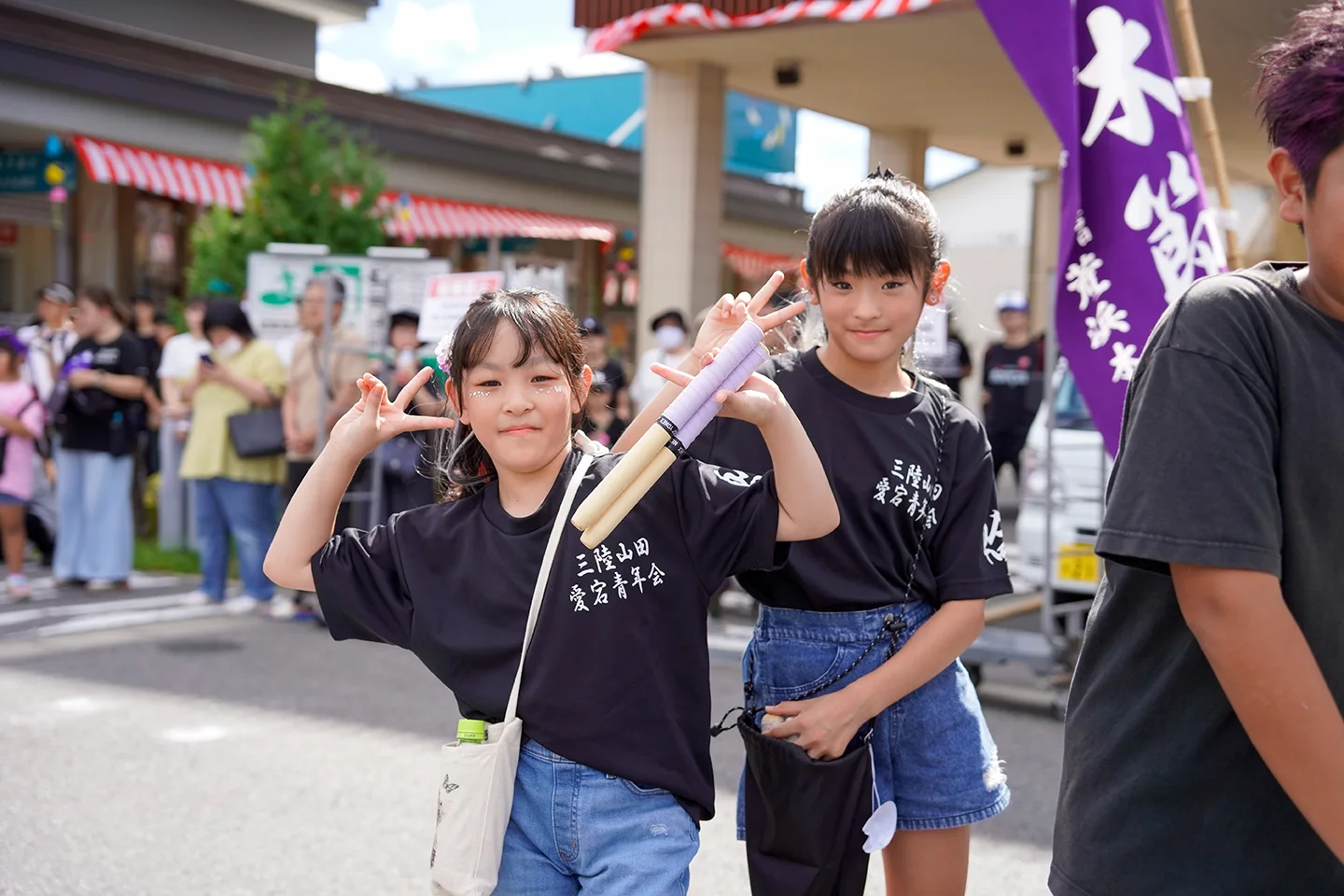 山田祭りでバチを手にピースする愛宕青年会の子どもたち