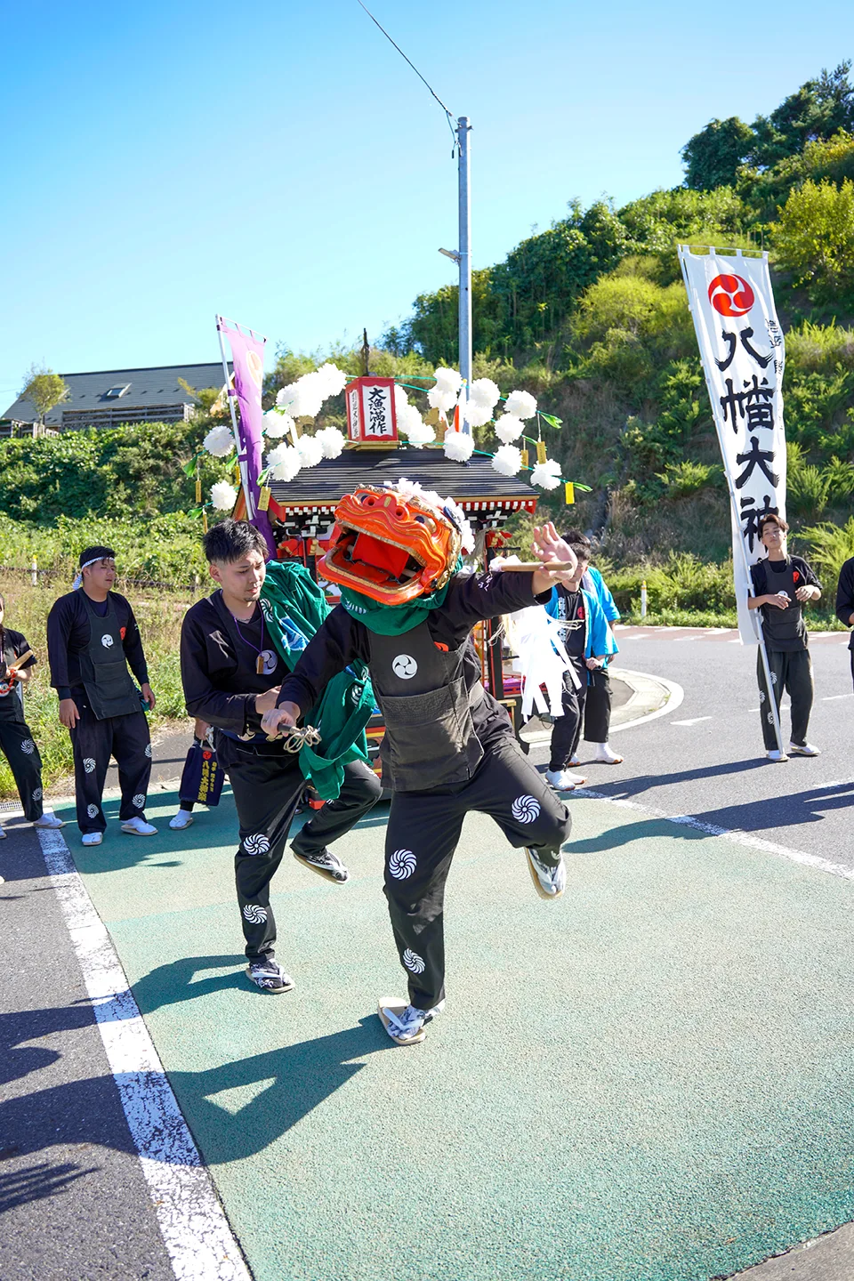 山田祭りで八幡大神楽の幟の前、跳ねるように舞う獅子舞