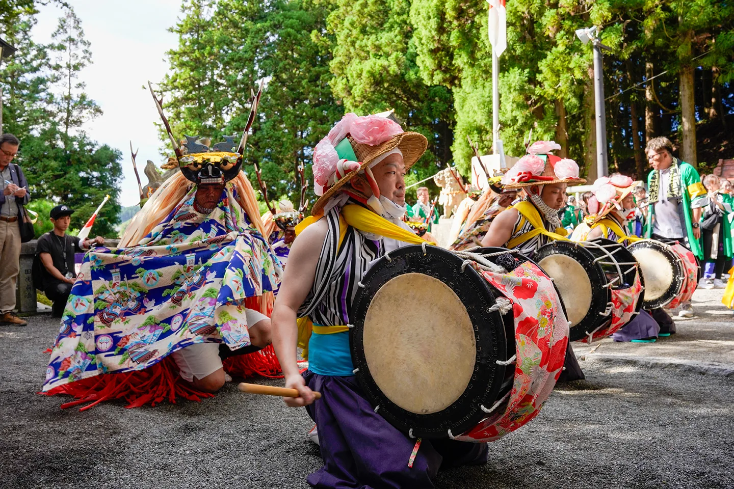 山田祭りで胸に太鼓を抱えて奉納する踊り手と鹿頭の装束の一行